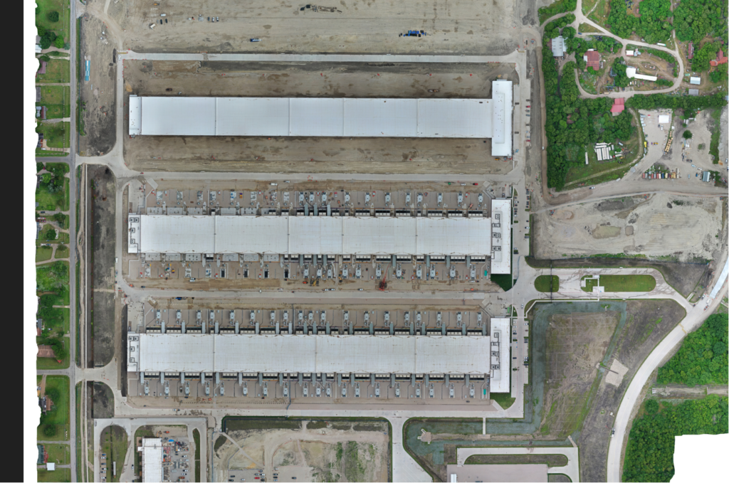An aerial view of three long buildings that stretch horizontally across the image