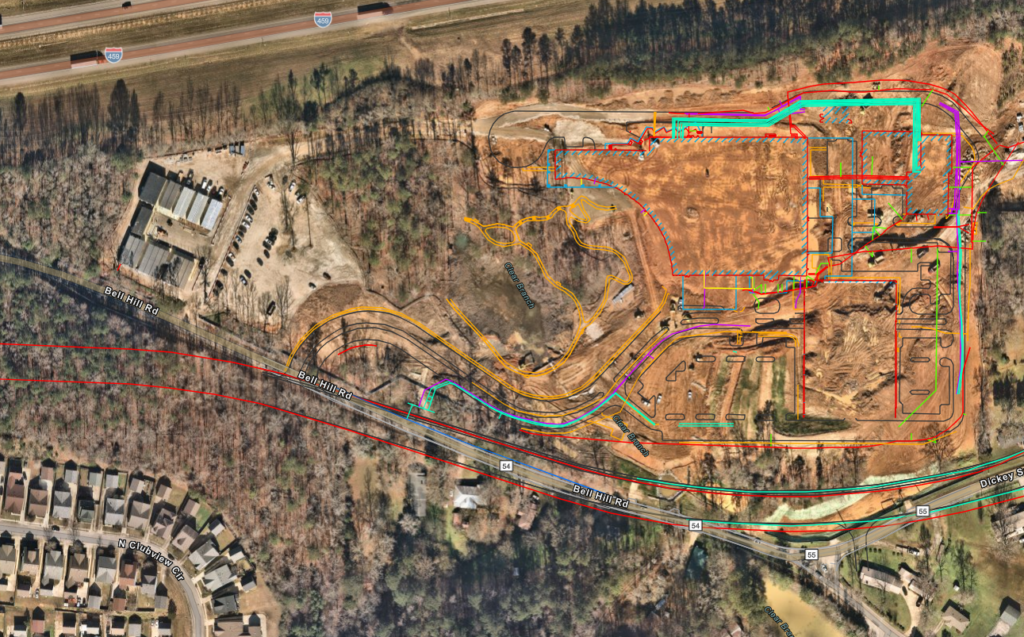 An aerial image of a construction site is marked with lines of different colors, which indicate the placement of utilities