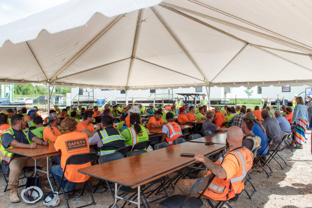 Construction workers gathered under a tent for a celebration