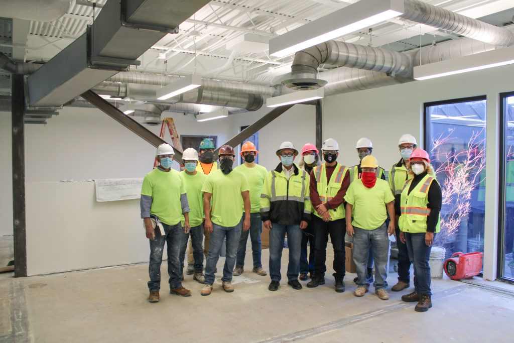 A group of construction employees in an unfinished office space