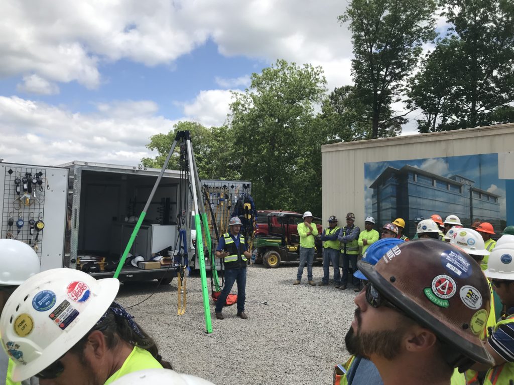 Group of workers watching a fall protection demo on a jobsite