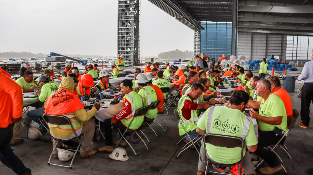 Construction workers gather around a table during a party on a construction site