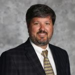 Professional headshot of a man with a beard, wearing a suit and tie, representing innovation in Construction Technologies.