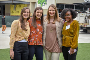 Four women from Women's Operational Resource Group posing for a photo together at an outdoor event supported by Brasfield & Gorrie.