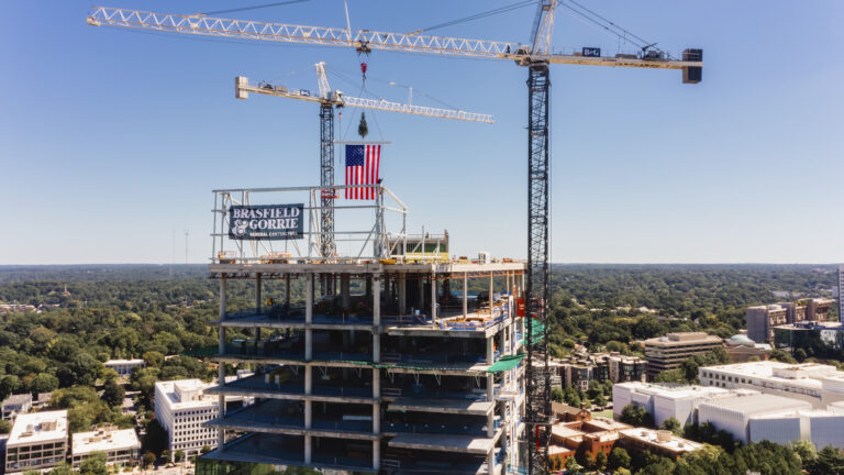 Construction cranes towering over the Midtown Union's Class-AA Office Tower under development against a clear sky.