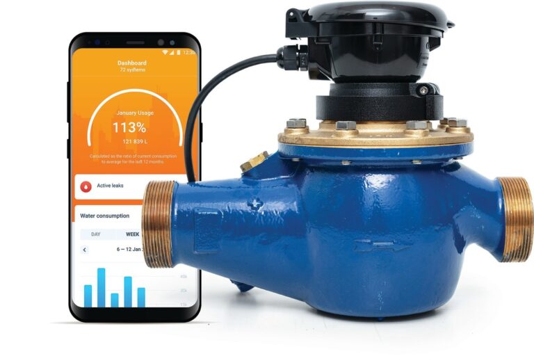 Smartphone displaying water leak damage data next to an industrial water meter managed by Brasfield & Gorrie.
