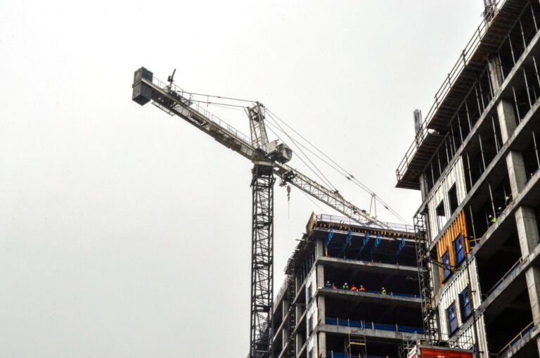 Construction site of the 760 Ralph McGill Office Tower with tower crane and partially built structure against a cloudy sky, managed by Brasfield & Gorrie.