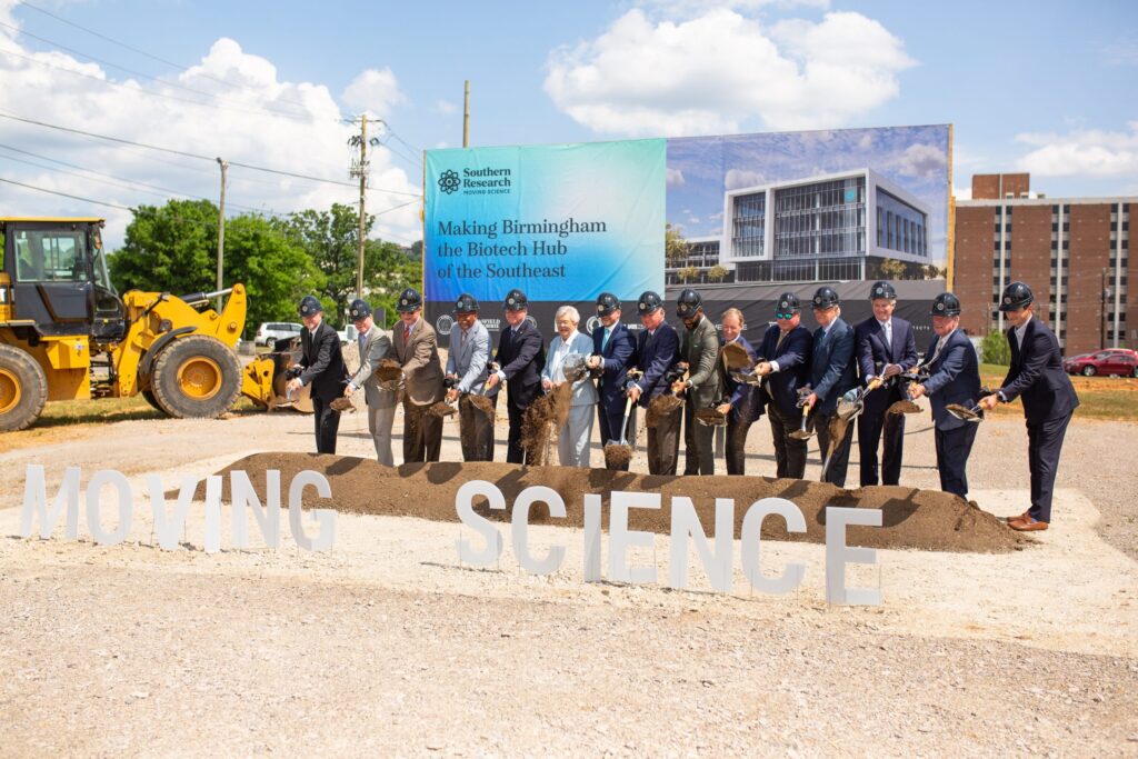 Group of individuals in hardhats participating in a groundbreaking ceremony for the Southern Research Biotech Center.