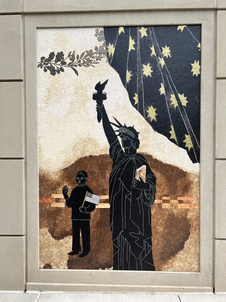 Mosaic artwork depicting the statue of liberty as a symbol of justice, with a patterned robe and a child holding a book and waving.