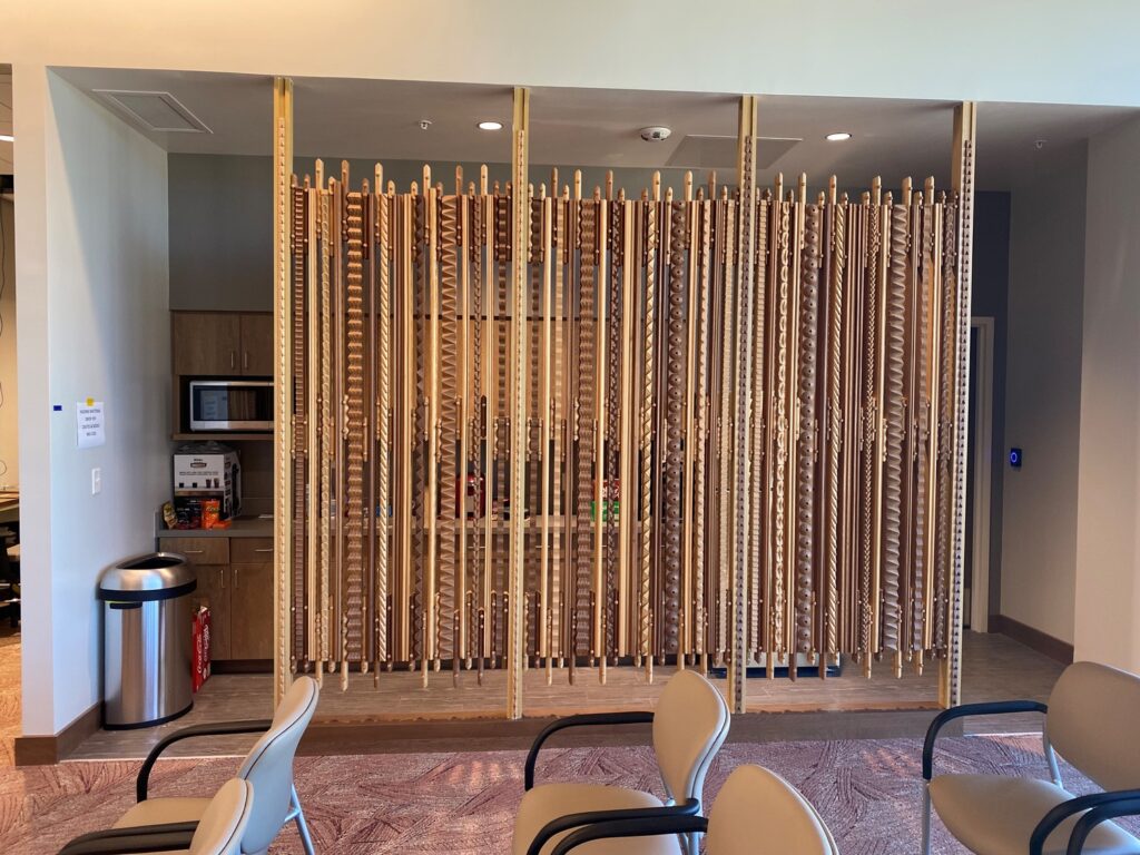 Wooden room divider featuring symbols of justice in a modern office space.