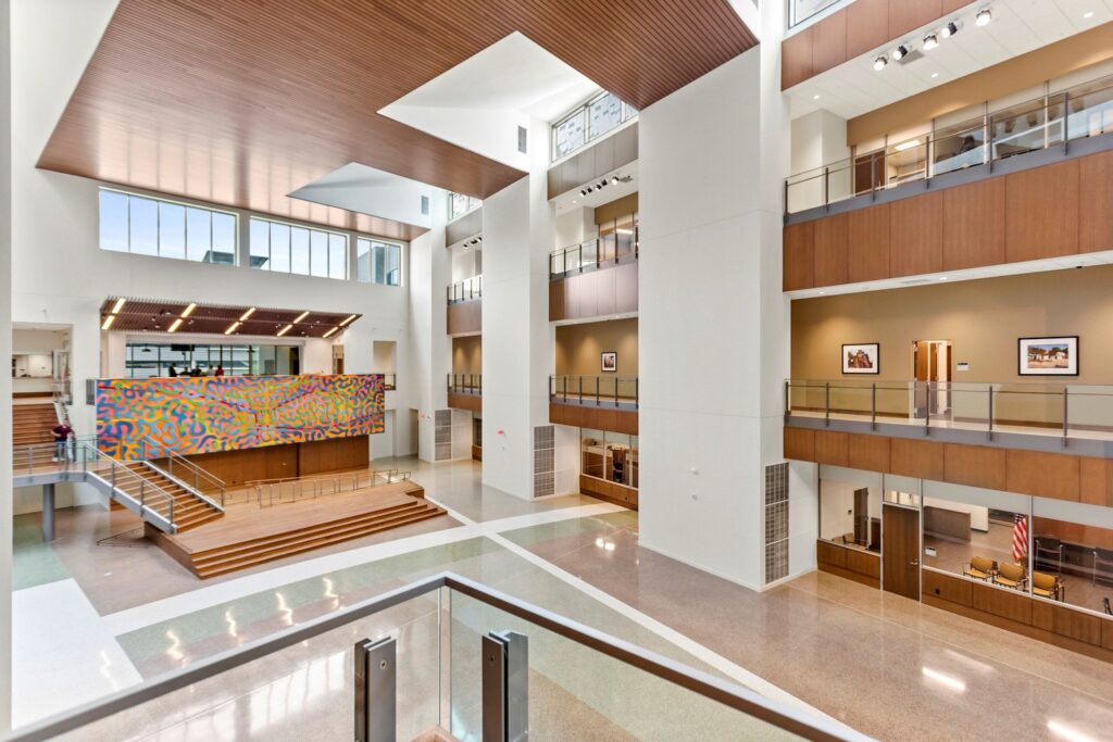 Spacious modern atrium with colorful art installations, featuring symbols of justice, and multiple levels.