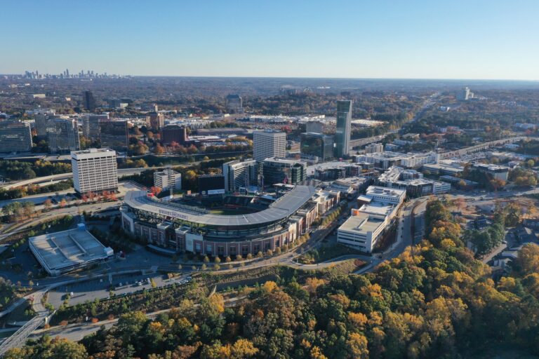 Aerial view of Truist Park baseball stadium in Atlanta, surrounded by office buildings and autumnal trees near the Brasfield and Gorrie headquarters.
