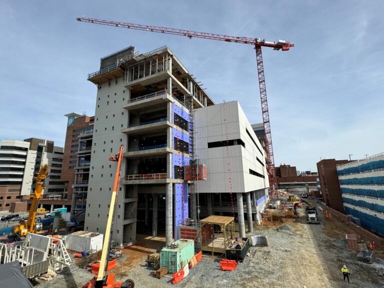 Construction site in Winston-Salem with a multi-story Healthcare Tower under development and cranes.