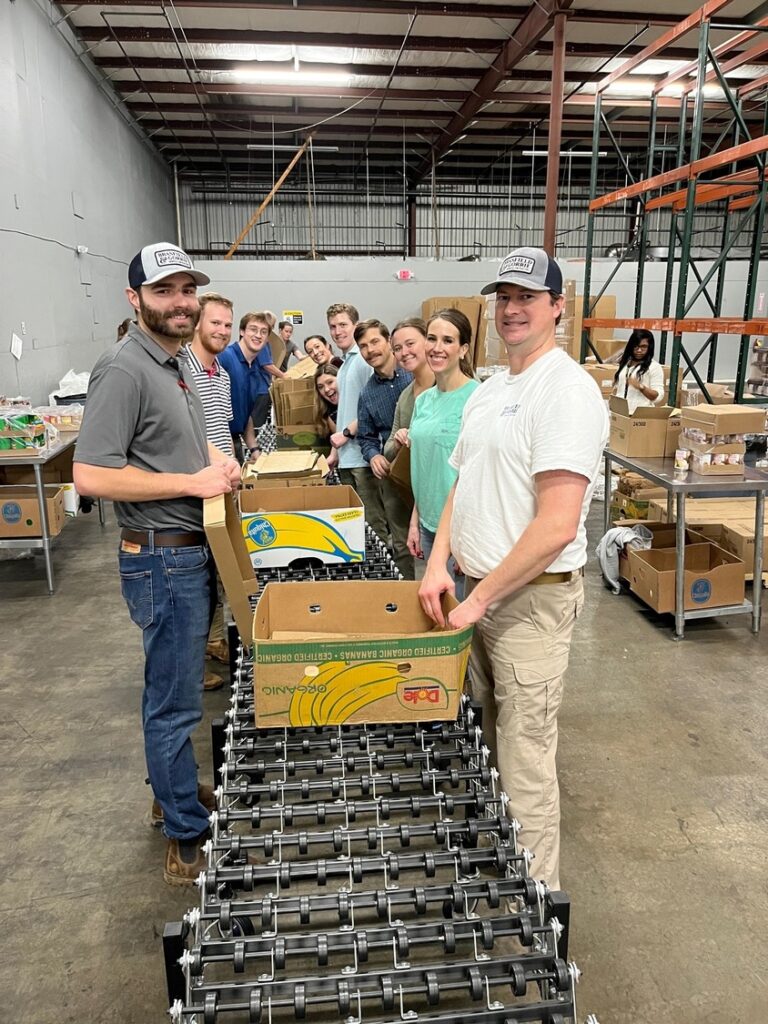 Volunteers at a food bank packing boxes of supplies for distribution.