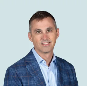 Dustin Smith wearing a blue plaid blazer and a light blue button-down shirt.