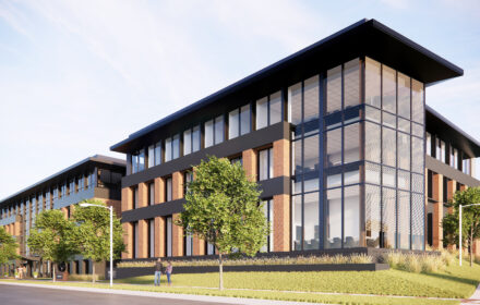 An office building rendering. The structure is three stories tall with significant windows and trees in front.