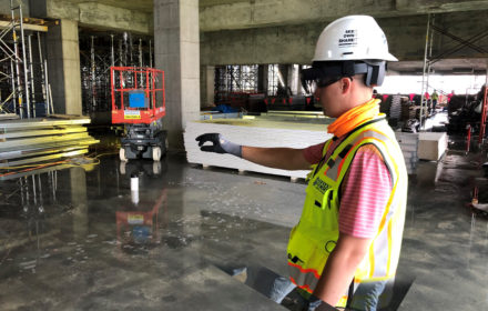 A man in a hard hat tests an augmented reality device on a jobsite