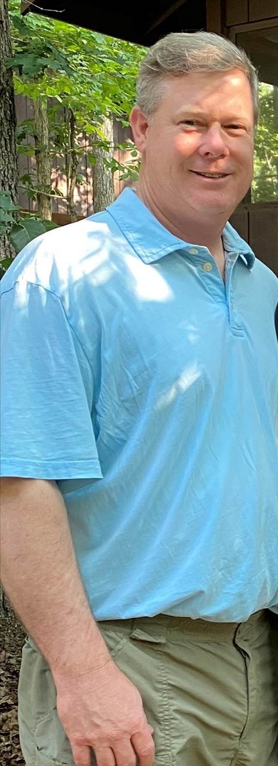 A man in a blue shirt standing outdoors