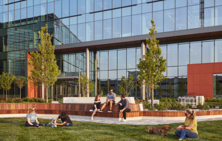An office building exterior with people and pets walking outdoors