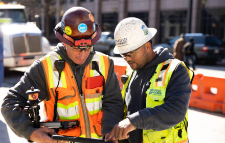 Two construction workers looking at tablet