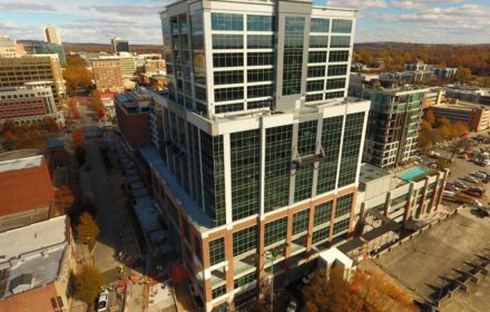 Large Glass Building Amid Greenville Skyline With Fall Colors